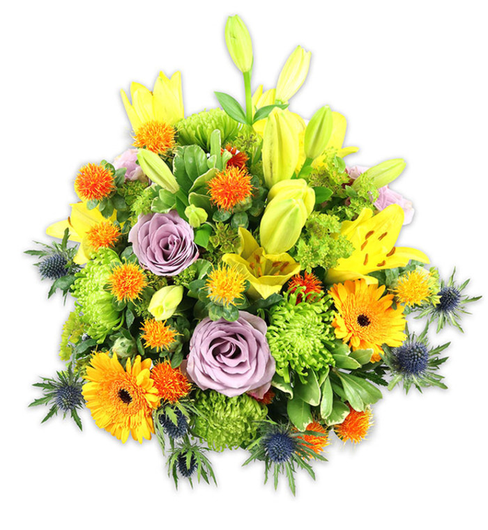 A striking, texturally rich floral arrangement set against a pristine white surface, composed to read as both modern and warmly familiar-like something ordered for a family gathering near Main Road or to surprise someone who frequents Raphael Park. Bright yellow Asiatic lilies dominate the verticals, some opening wide with their signature freckled faces, others remaining as smooth, chartreuse-tinged buds that add optimism and upward movement. Pale lavender-purple roses sit serenely at the centre, their layered petals offering a gentle, classical counterpoint to the bolder elements. Orange Gerbera daisies provide radiant focal points with their flat, ray-like petals and darker central discs; nearby, lime-green button chrysanthemums supply plush, almost moss-like texture that fills the composition with verdant volume. Interspersed spiky globe accents in orange and golden-yellow introduce energetic pops of color and tactile contrast, reminiscent of hand-selected market finds. Distinctive blue-grey Eryngium thistles project from the lower edges, their starry, spiky bracts creating a cool structural note against the warm palette. A variety of foliage-broad lily leaves, glossy fillers, and slender stalks-binds the bouquet together, giving it a garden-harvest feel even in its polished form. Captured in soft, diffuse light, the bouquet exudes conviviality and heartfelt sentiment: a celebratory centrepiece, a bright get-well offering, or a considered thank-you gift sourced with local care in Romford.
